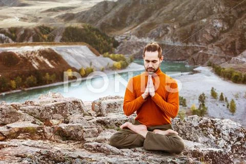Man meditating in the mountains Stock Photos