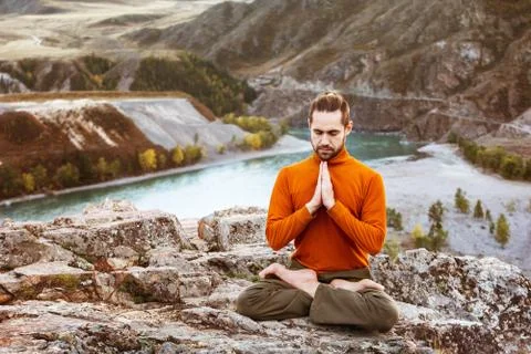 Man meditating in the mountains Stock Photos