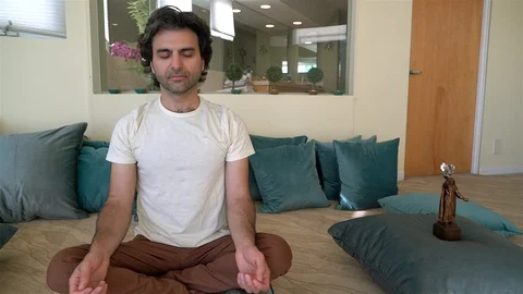 Man Meditating Next to Statue Stock Footage 99480473