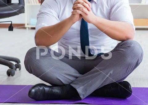 Man meditating in the office to cope with stress Stock Photos