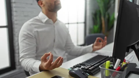 Man meditating at office desk with computer, taking deep breath during work.. Stock Footage 301115333
