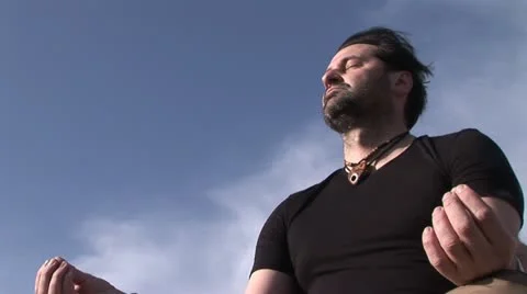 Man meditating on a rock Stock Footage 24655310