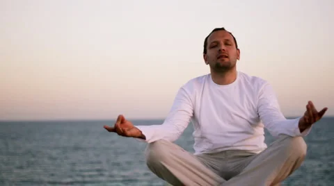 Man meditating by the sea Stock Footage 1059772