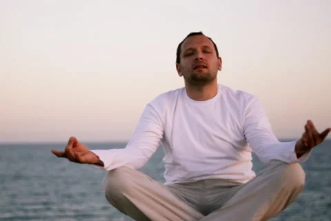 Man meditating by the sea Stock Footage 1059778