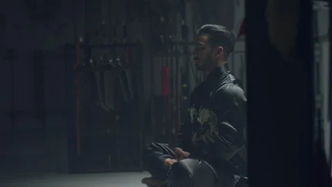 Man meditating before training in martial arts Stock Footage 279851173