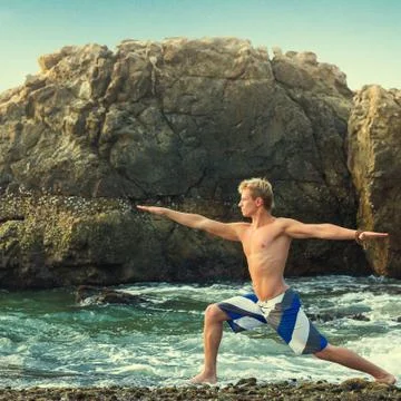 Man meditating in warrior pose Stock Photos