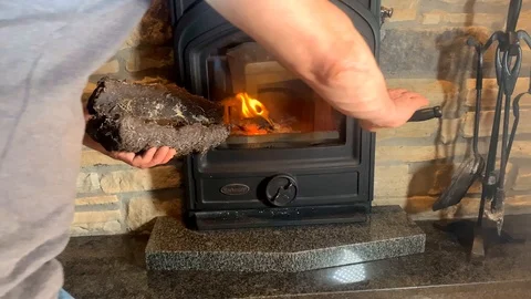 A man melts a fireplace, setting fire to wood and peat, the concept of the he Video stock 125814634