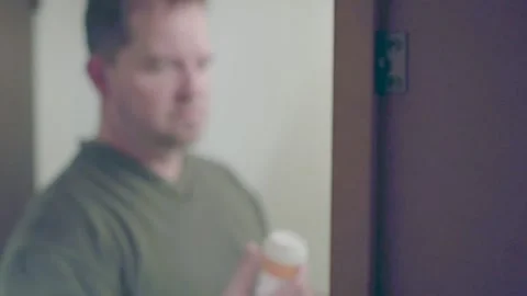 Man with mental illness grabs bottle of pills and swallows them all in bathro Video stock 169734312