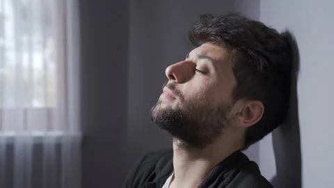 Man with mental illness is sitting by the wall at home. Stock-Footage 222486288