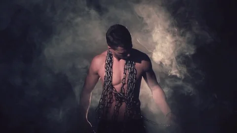 Man in metal chains in smoke. Stock Footage 80848758
