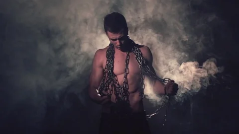 Man in metal chains in smoke. Vídeos de archivo 80848797