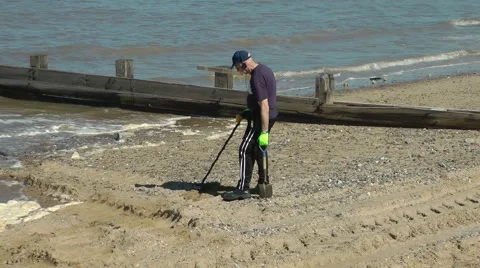 Man metal detecting detector sand sea beach find breakwater Stock Footage 49461360