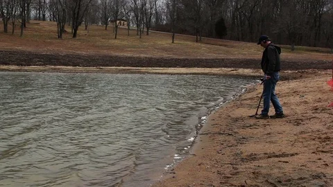 Man Metal Detecting on Overcast Sandy Beach in Missouri Video stock 100612764