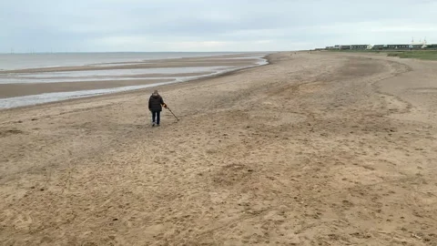 A man with a metal detector detecting for metals and buried treasure on Stock Footage 252874164