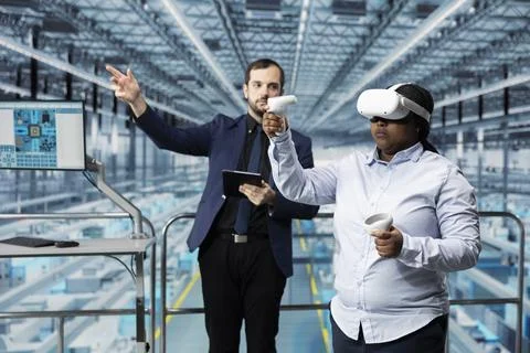 Man in microchip smart factory using VR glasses gear to visualize machinery data 写真素材