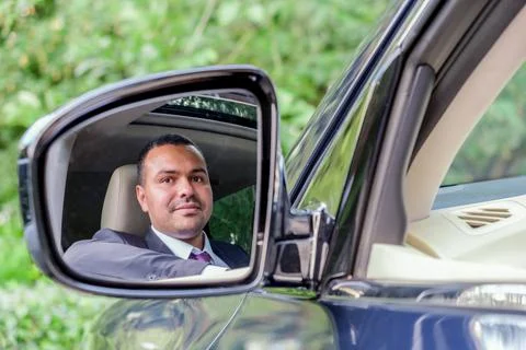 Man of Middle Eastern appearance in a business suit sitting behind the wheel  Stock Photos