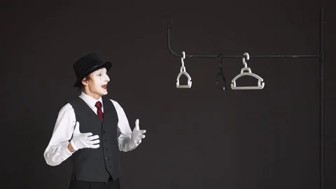 Man MIME puts on the clothes themselves. He stands at the closet on black Stock Footage 73799005