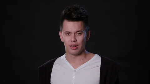 A Man Mimicing Against a Black Background Stock Footage 87326530
