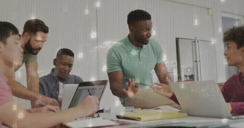 Man in mint polo leading tech review after right peer pointing at laptop binary Stock Footage 331757159