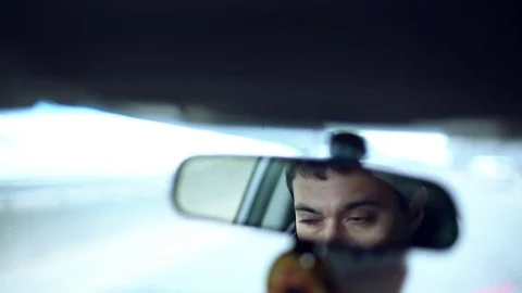 Man in a mirror while driving car on a busy road in a city. Stock Footage 71025944
