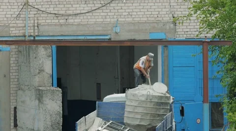 Man mixes cement in a large capacity. A container of cement is in the body truck Stock Footage 64941839