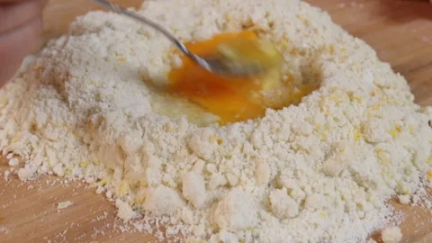 A man mixes egg and flour to make dough Stock Footage 286097335