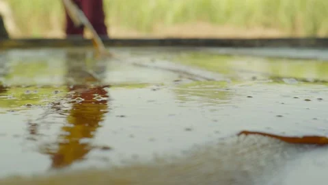 A man mixing and making jaggery in an iron vessel india Stock Footage 221888912