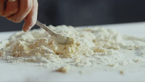 Man mixing egg and flour dough on a table Stock Footage 274698976
