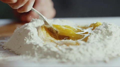 Man mixing egg with flour on a table Stock Footage 274614864