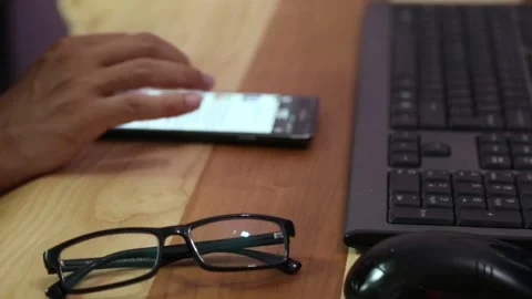 A man with mobile phone on the background. Glasses on the table. Stock Footage 338122887
