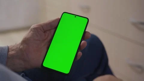 Man with modern green screen smartphone at home. 库存影片 295126338