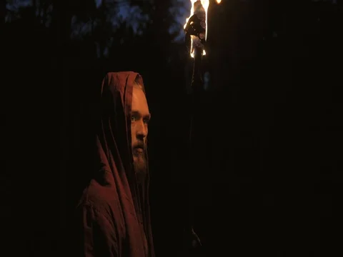 Man in monastic robe with burning torch 库存影片 80288344