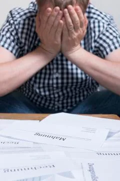 A man with money problems with a Bills stack up the table Stock Photos