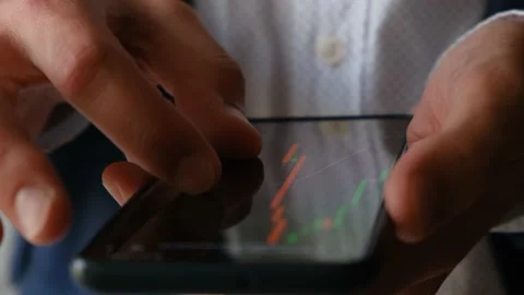 A man monitors the dynamics of financial indicators on a smartphone, close-up Video stock 205086901