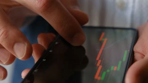 A man monitors the dynamics of financial indicators on a smartphone, close-up Stock Footage 205087077