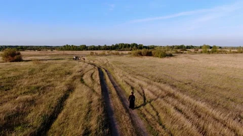 A man monk rides an electric unicycle across the field. Stock Footage 160762953