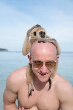 Man with monkey on the beach Foto stock
