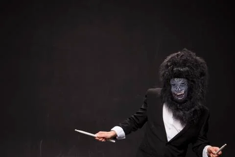 A man in a monkey mask on a black background Stock Photos