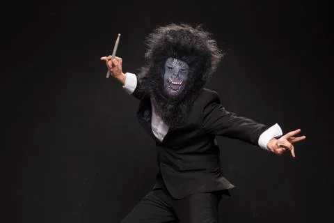 A man in a monkey mask on a black background Stock Photos