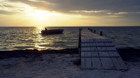 Man moors a boat at sunset 스톡 동영상 120205423