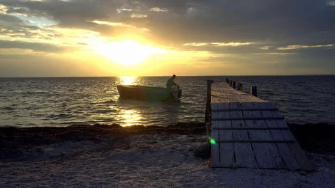 Man moors a boat at sunset Video stock 120800939