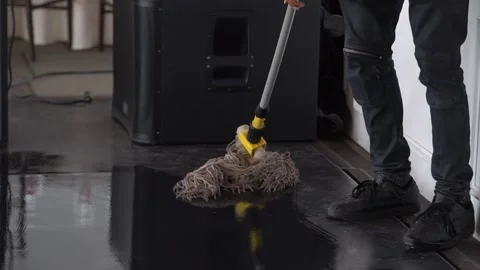 A man is mopping the floor with a mop and enjoying the work . Stock Footage