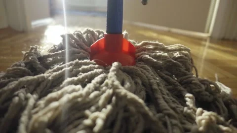 A man is mopping the floor with a mop. The camera is mounted on a mop. Close up. Stockbeeldmateriaal 221558521