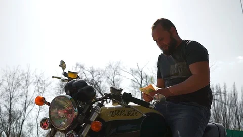  A man on a motorcycle counts money Stock Footage 88548929