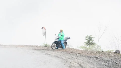 Man on motorcycle puts on helmet. Video stock 305370380