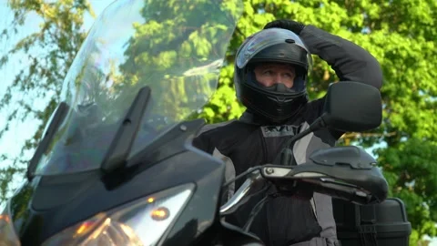A man on a motorcycle starts the engine and drives away Stock Footage 196715018