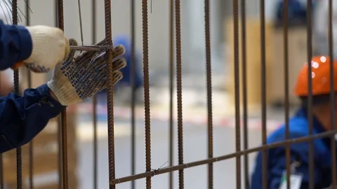 Man mount metal structure, frame made of rebar rods. Hands of worker in gloves Stock Footage 126357807