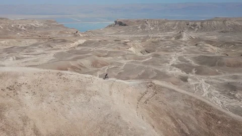 Man Mountain biking alone downhill fast a sharp desert ridge 스톡 동영상 239760723