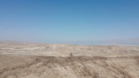 Man Mountain biking alone downhill fast a sharp ridge line desert 스톡 동영상 239760724