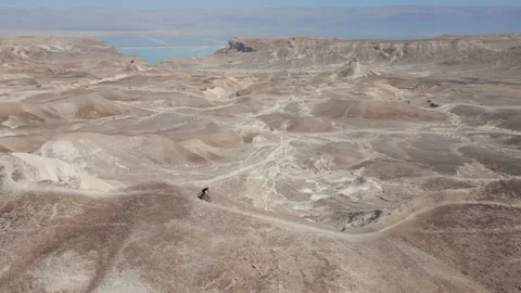 Man Mountain biking alone downhill a sharp ridge fast desert 스톡 동영상 239760739